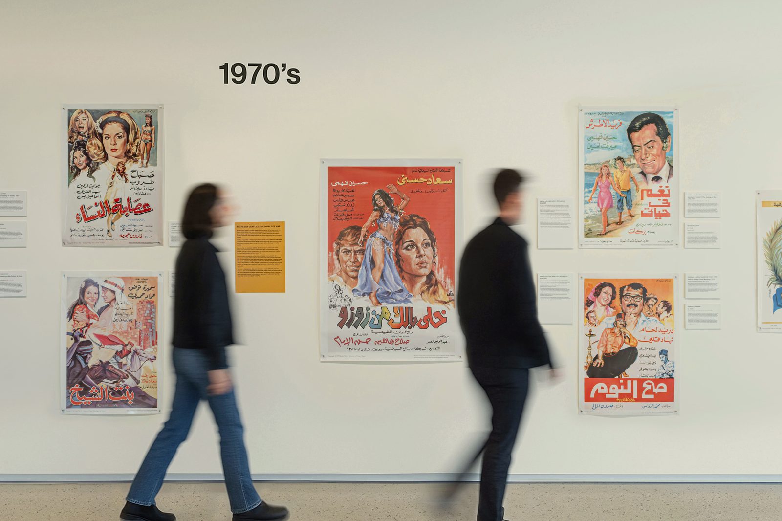 Visitors viewing the 1970s poster wall at the exhibition